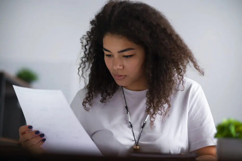 Niña leyendo un documento.