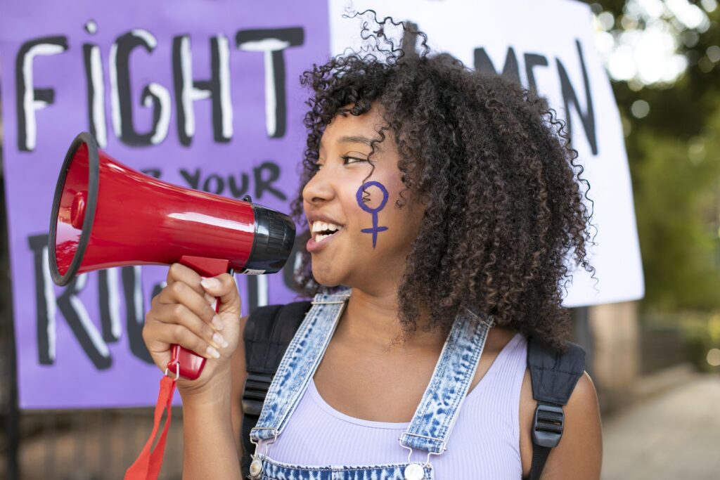 Imagen de una mujer con megáfono luchando por los derechos de las mujeres.