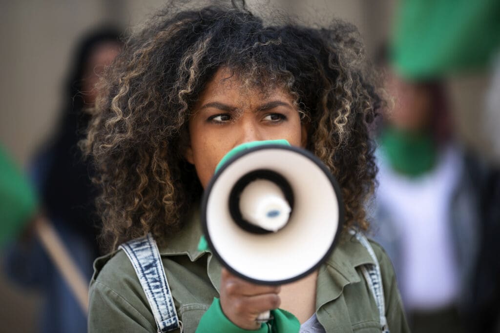 Mujer joven en una manifestación que representa a la juventud en la política.